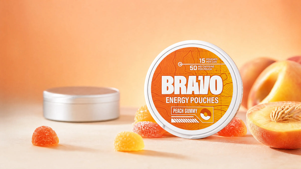 Bravo Peach Gummy caffeine pouch can in sharp focus with peach gummy candies, and a generic unbranded competitor tin blurred in the background — FRISS vs Bravo caffeine pouch review hero