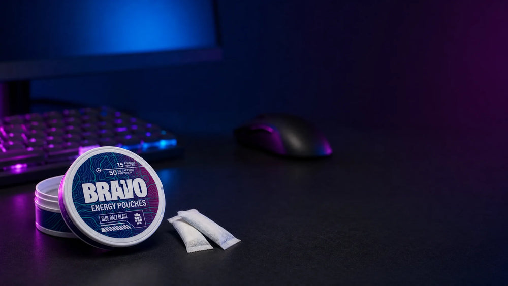 Bravo Blue Razz Blast caffeine pouch can on a dark gaming desk with an RGB-lit keyboard in the background