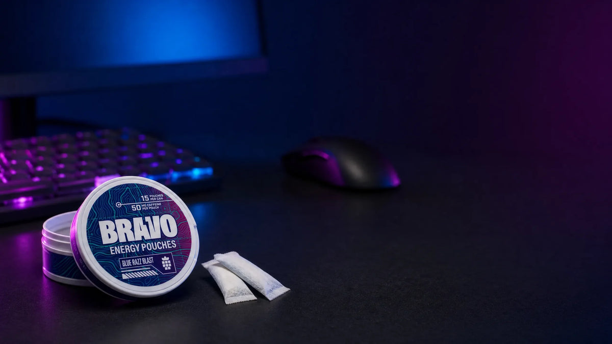 Bravo Blue Razz Blast caffeine pouch can on a dark gaming desk with an RGB-lit keyboard in the background