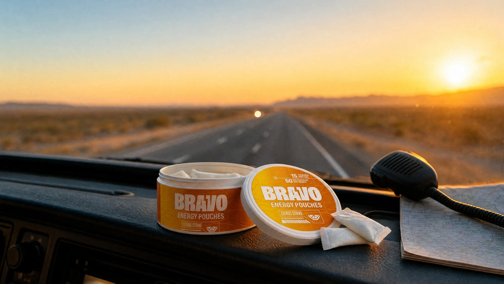 Open can of Bravo Citrus Strike caffeine pouches on a truck dashboard with an open highway at sunset