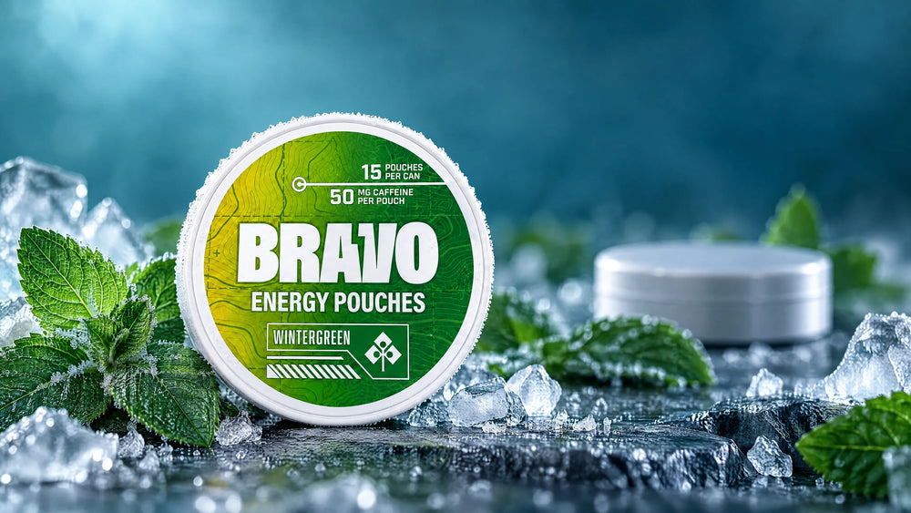 Bravo Wintergreen caffeine pouch can beside fresh mint and ice, with an unbranded competitor tin softly out of focus in the background