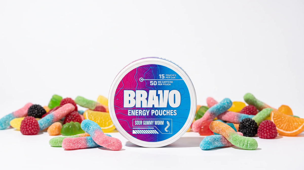 Bravo Sour Gummy Worm caffeine pouch can surrounded by colorful gummy candy, illustrating the best caffeine pouch flavors of 2026