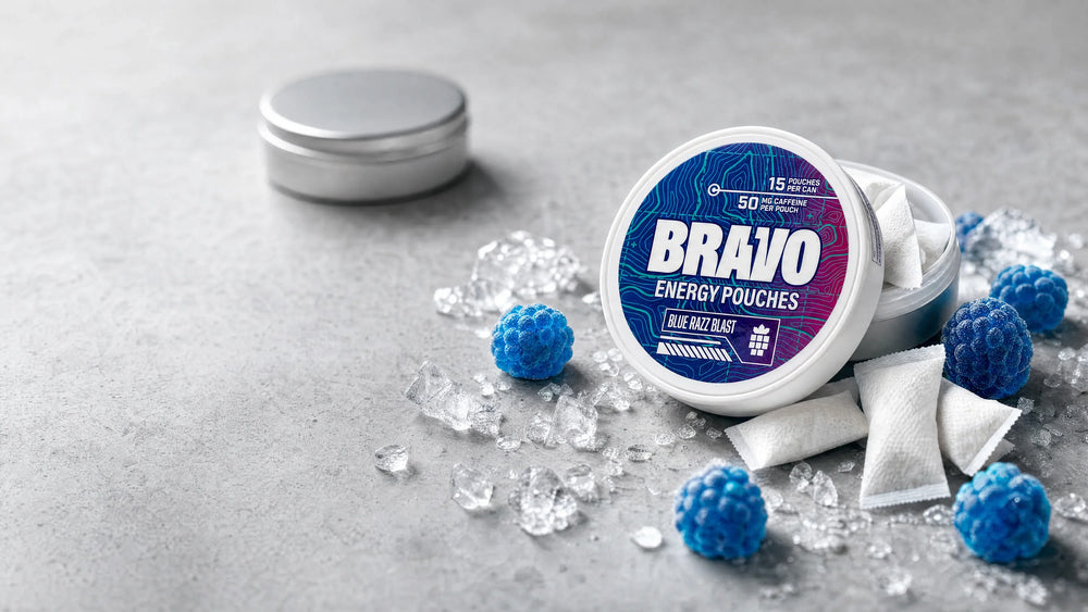 Bravo Blue Razz Blast caffeine pouch can on a countertop with blue raspberry candies and ice, a plain unbranded tin blurred in the background