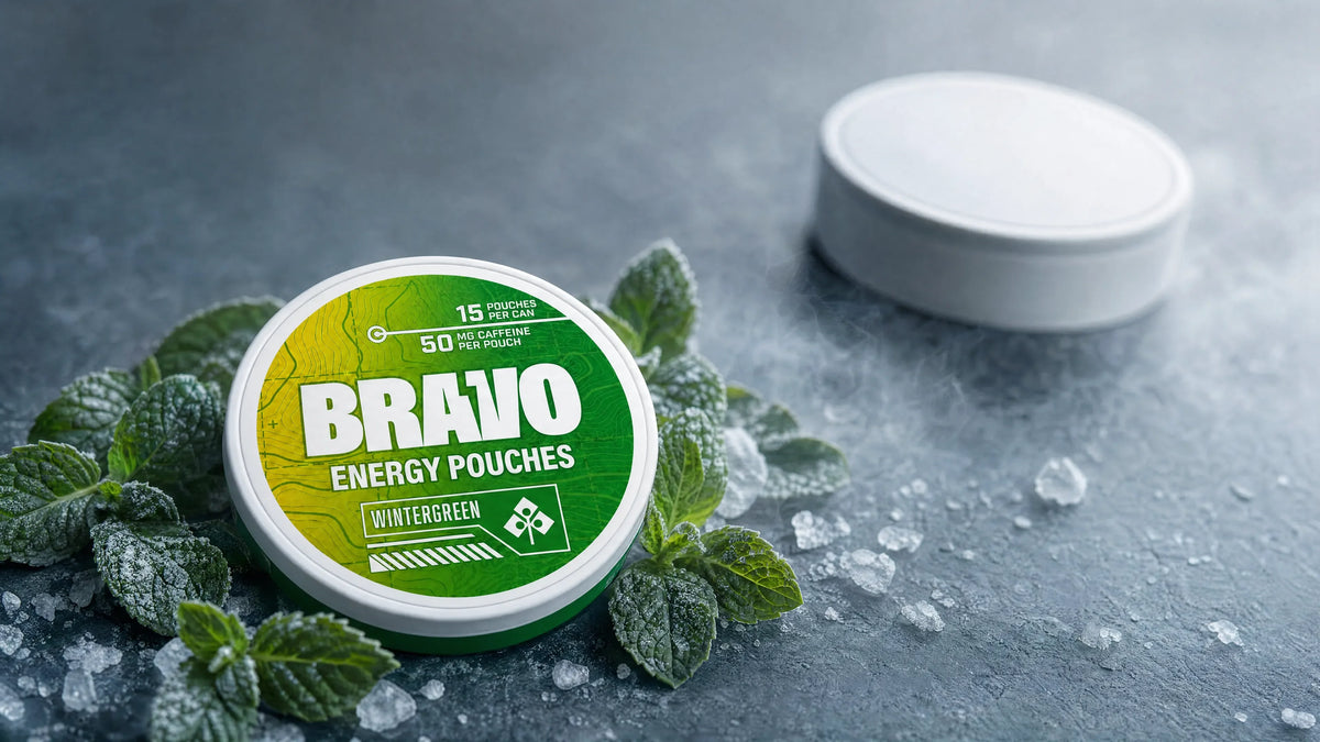 Bravo Wintergreen caffeine pouch can in sharp focus with mint leaves and frost, hero image for the Fully Loaded ALPHA Fuel vs Bravo comparison