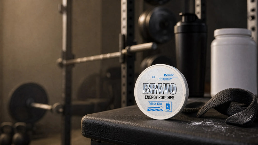 Bravo Energy Drink caffeine pouch can on a gym bench with a blurred shaker bottle and pre-workout tub in the background