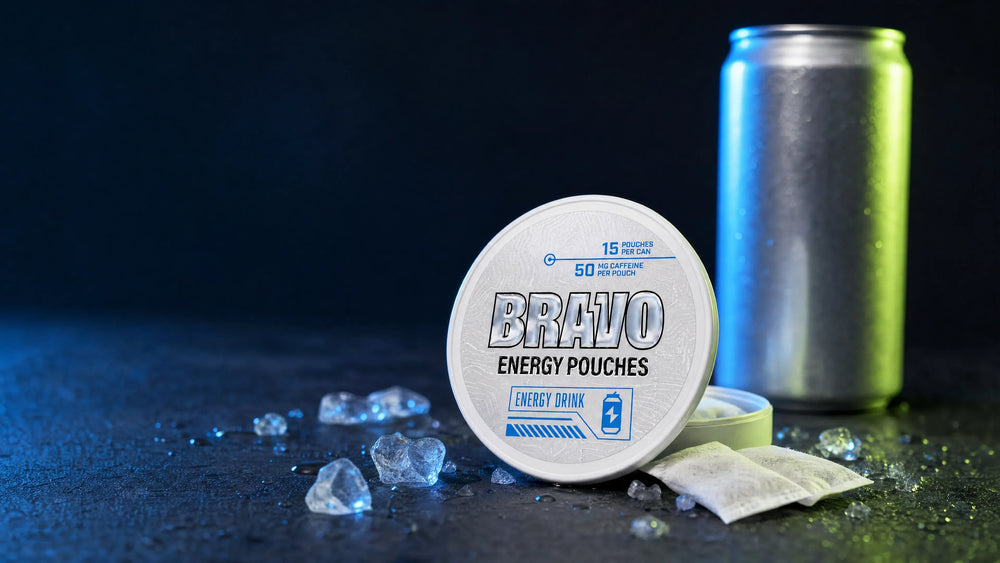 Bravo Energy Drink flavor caffeine pouch can in sharp focus on dark slate with ice, with a plain unbranded beverage can blurred in the background